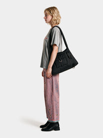 Black padded cargo shoulder bag worn on the shoulder